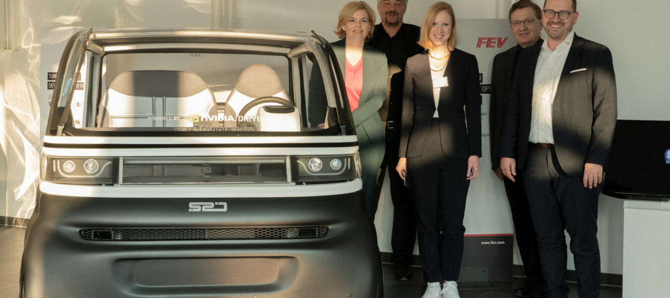 Gruppenfoto bei der FEV Group mit Annika Fohn und Julia Klöckner vor dem Fahrzeug SVEN